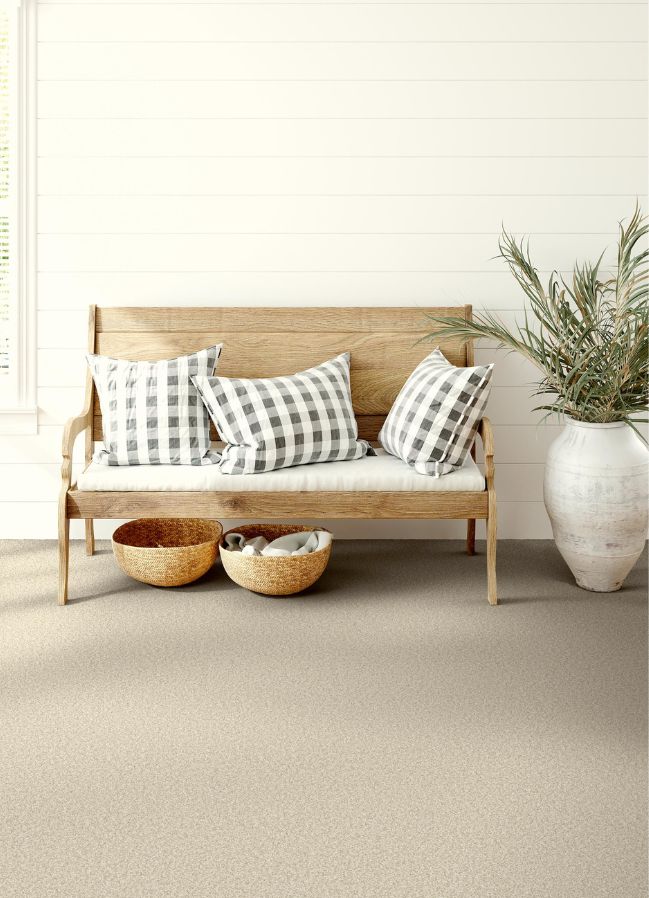 durable beige carpets in a bright entryway with a bench
